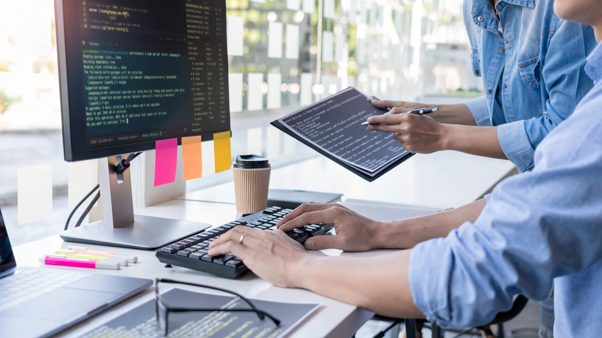 コードを確認しながらシステム開発を進めるエンジニアチーム